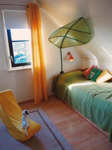 a bedroom with a bed and a chair and a window at Villa Julia 148 in Callantsoog