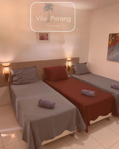 due letti in una stanza con un cartello che dice vida di Vila Porang Pousada a São Miguel dos Milagres