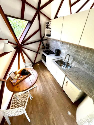 a kitchen with a table and a sink in a room at Cabana da Lua - Sua melhor experiência em um domo in Teresópolis