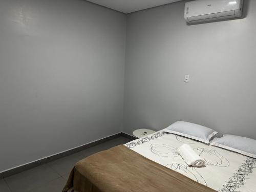 a white room with a bed in a room with at Apto Completo - 100m da Av Weyne Cavalcante, Centr in Canaã dos Carajás