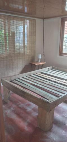 RivasにあるRustic two bedroom house right by the Chirripo riverの大きな木製ベッドが備わる客室です。