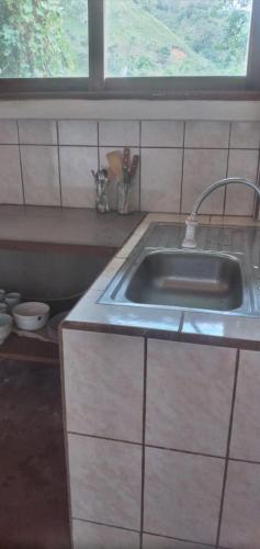 RivasにあるRustic two bedroom house right by the Chirripo riverのシンクと窓のあるキッチン