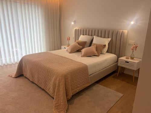 ein Schlafzimmer mit einem großen Bett und Kissen in der Unterkunft Casa Maria Eduarda in Assureira