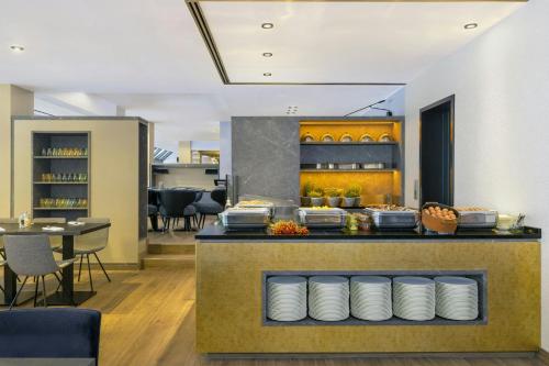 a restaurant with a counter with plates on it at Le Méridien Frankfurt in Frankfurt/Main