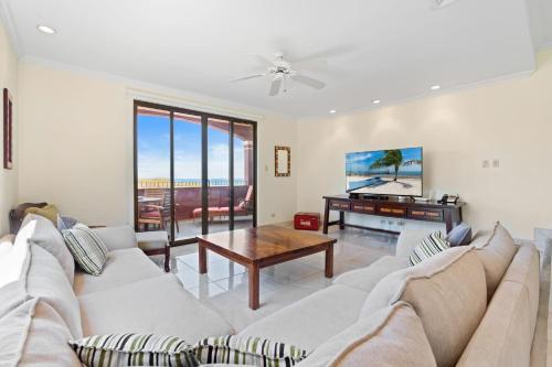 uma sala de estar com um sofá e uma mesa em Recently Renovated Luxury Condo with Resort-Style Beach Club Access and Ocean Views em Playa Conchal