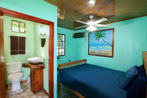 大玉米岛Hospedaje Rosa Del Mar & Sweets Cafe的一间卧室，里面有一张床和一个吊扇