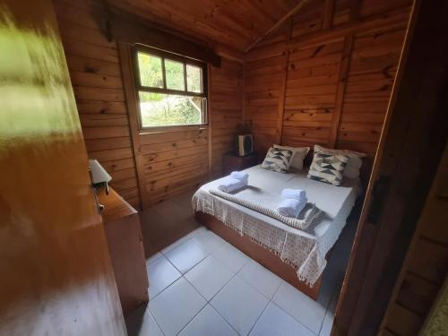 Giường trong phòng chung tại Sítio com Casa de Madeira com 2 quartos 100m2 px Centro de Salesópolis