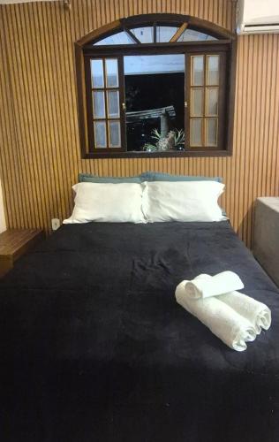 a bedroom with a bed with two towels on it at Aconchego IV in Miguel Pereira