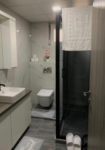 a bathroom with a toilet and a glass shower door at Aura in Kumanovo