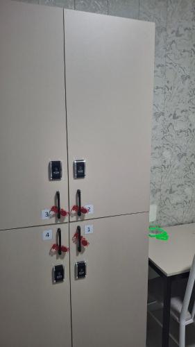 ein weißer Kühlschrank mit roten Schuhen darauf in der Unterkunft AI Hostel in Bischkek