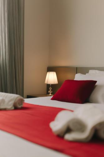 a bedroom with a red and white bed with a red blanket at Lagoa Flat Hotel in Lagoa da Prata