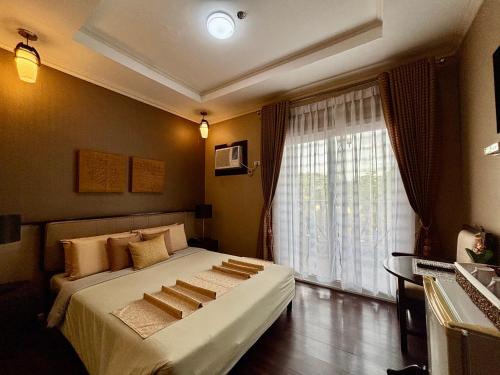 D' Leonor Inland Resort and Adventure Park في مدينة دافاو: غرفة نوم بسرير كبير ونافذة