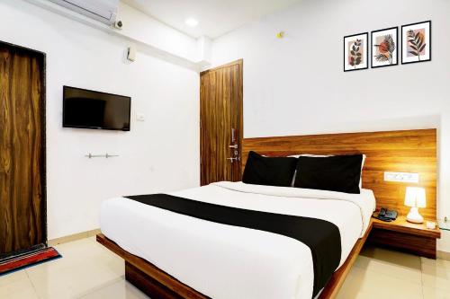 a bedroom with a large bed and a tv at Super Hotel O Nashik Road Formerly The Address Hotel in Nashik