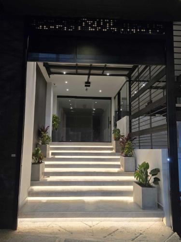 a hallway of a building with stairs and potted plants at Rooca Urban in Medellín