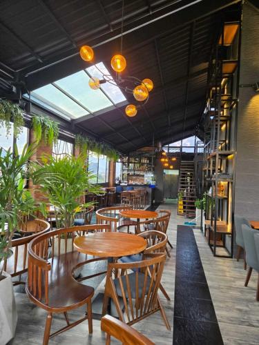 a restaurant with wooden tables and chairs and plants at Rooca Urban in Medellín