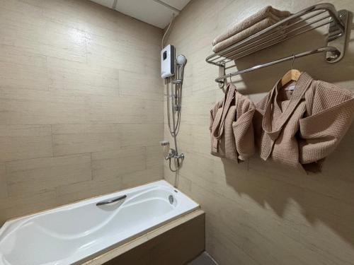 D' Leonor Inland Resort and Adventure Park في مدينة دافاو: حمام مع حوض استحمام أبيض كبير ومناشف