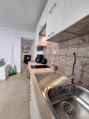 ガラヒディにあるAeolus Apartment IIのステンレス製のシンクとカウンターを備えたキッチン