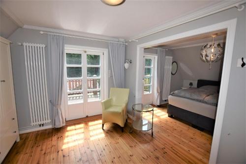 ein Schlafzimmer mit einem Bett, einem Tisch und einem Stuhl in der Unterkunft Haus am Strandweg in Hohwacht