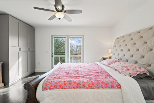 ein Schlafzimmer mit einem Bett und einem Deckenventilator in der Unterkunft Hawk Mountain Song- Massanutten Home with hot tub! in Massanutten