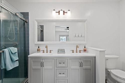 ein weißes Badezimmer mit Waschbecken und Dusche in der Unterkunft Hawk Mountain Song- Massanutten Home with hot tub! in Massanutten