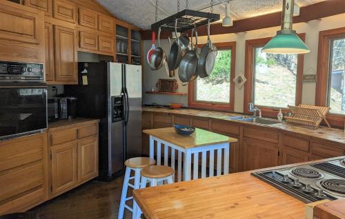 a kitchen with wooden cabinets and a refrigerator and a table at The Round House Views for Days! in Luray