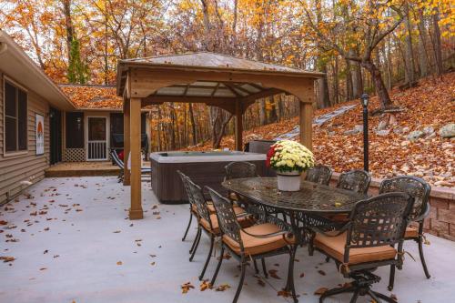a patio with a table and chairs and a hot tub at Green Mountain Song-Massanutten Mountain in McGaheysville
