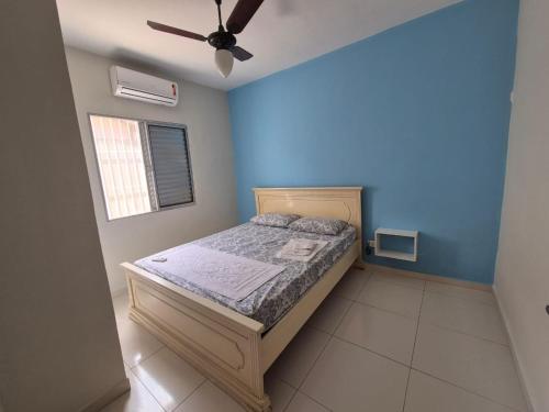 a bedroom with a bed with blue walls and a ceiling at Casa Praia Bertioga in Bertioga