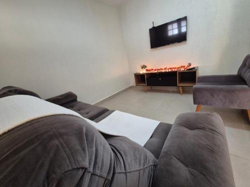 a living room with a couch and a flat screen tv at Casa Praia Bertioga in Bertioga