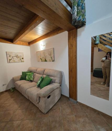 a couch in a living room with a person taking a picture at La Casa di Teo Sorrento Coast in Sant'Agnello