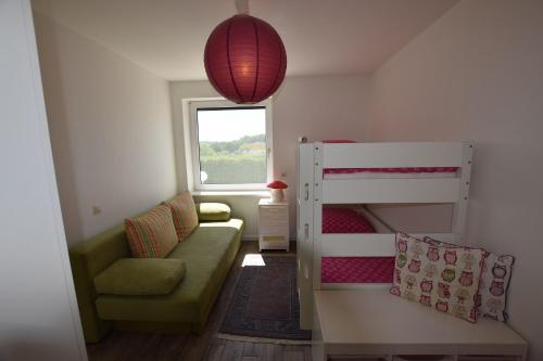 ein kleines Zimmer mit einem Etagenbett und einer Couch in der Unterkunft Hohes Ufer Mare Nostrum in Hohwacht