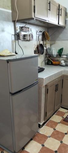 a kitchen with a refrigerator and a tile floor at Mhamid appartement in Mhamid