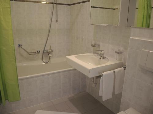 a bathroom with a sink and a shower and a tub and a sink at Lido Golf by Fewotessin in Ascona