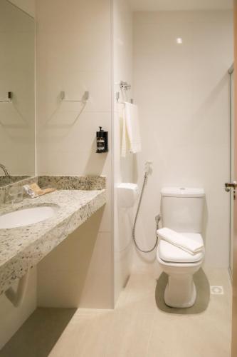 a bathroom with a toilet and a sink and a shower at Bristol Castanhal Hotel in Castanhal