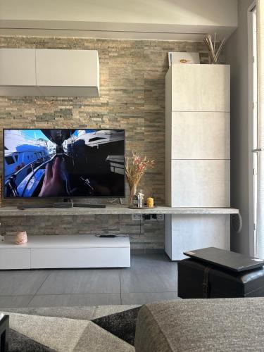 a living room with a flat screen tv on a brick wall at MXP-Milano-Torino Loft in Inveruno