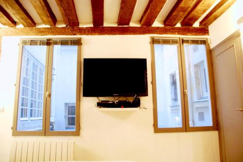 パリにあるスタジオ アブキルの壁に薄型テレビ(窓2つ付)