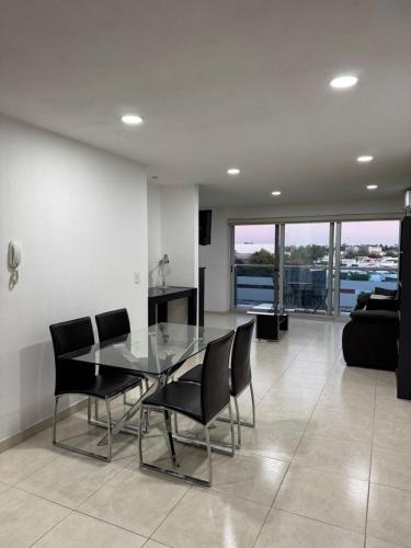Un comedor con una mesa de cristal y sillas negras. en Loft ideal para viajes de trabajo cerca del Poliforum, en León