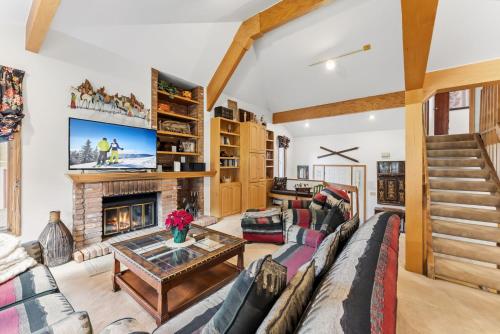 a living room with a couch and a fireplace at Mountain View Condo - Hot Tub Fireplace in Avon