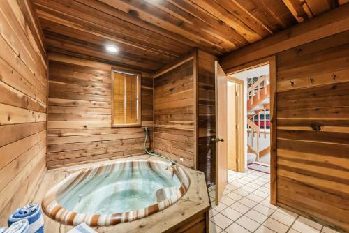 a jacuzzi tub in a room with wooden walls at Mountain View Condo - Hot Tub Fireplace in Avon