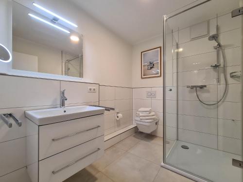 ein Badezimmer mit Dusche, Waschbecken und Toilette in der Unterkunft Meeresblick Pier 23 H2 WE 23 in Hohwacht