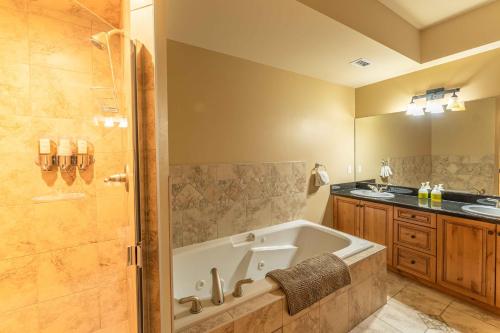 a bathroom with a bath tub and a sink at Cascade Penthouse by Canadian Rockies Vacation Rentals in Canmore