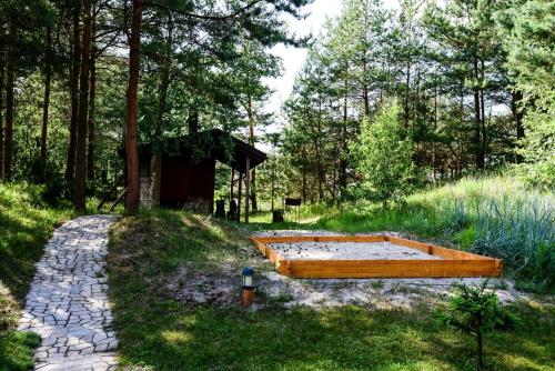 a large wooden bed in the middle of a field at Vila Ambasada in Šventoji