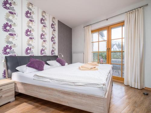 Un dormitorio con una cama grande y una ventana. en Ferienpark Freesenbruch Wohnung 2 1 - Möwennest, en Zingst