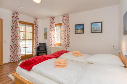 due letti bianchi in una stanza con finestre di Ferienpark Freesenbruch Wohnung 3 1 - Schöne Auszeit a Zingst