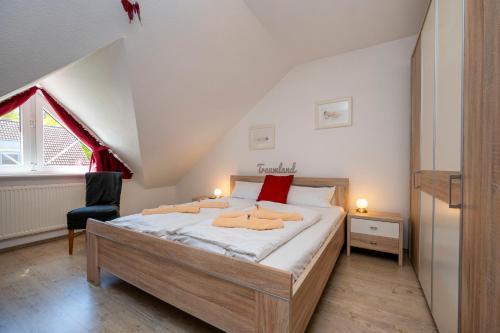 ein Schlafzimmer mit einem großen Bett im Dachgeschoss in der Unterkunft Ferienpark Freesenbruch Reihenhaus 8a - Eisbär in Zingst