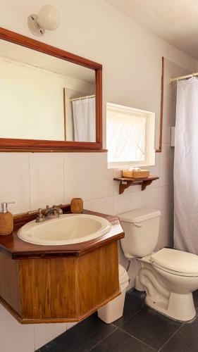 a bathroom with a sink and a toilet and a mirror at Casa Rábida Hotel Restaurante in Quito