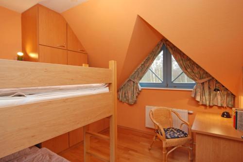 Ferienpark Freesenbruch Doppelhaushälfte 12a - Steuerrad في زنغست: غرفة مع سرير بطابقين مع مكتب ونافذة