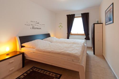 una camera da letto con un letto grande e una finestra di Ferienpark Freesenbruch Wohnung 4 2 - Ostseeperle a Zingst