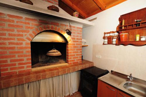 a kitchen with a brick oven with a bell in it at Apartments Luka & Sara in Zadar