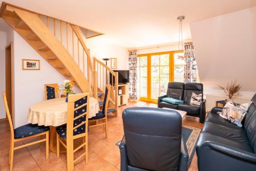 a living room with a table and chairs and a staircase at Ferienpark Freesenbruch Wohnung 3 5 - Muschelsucher in Zingst