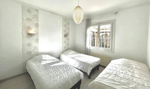 a room with two beds and a window at Agréable villa avec piscine à 100 m de la plage - 10B14J35 in Le Barcarès